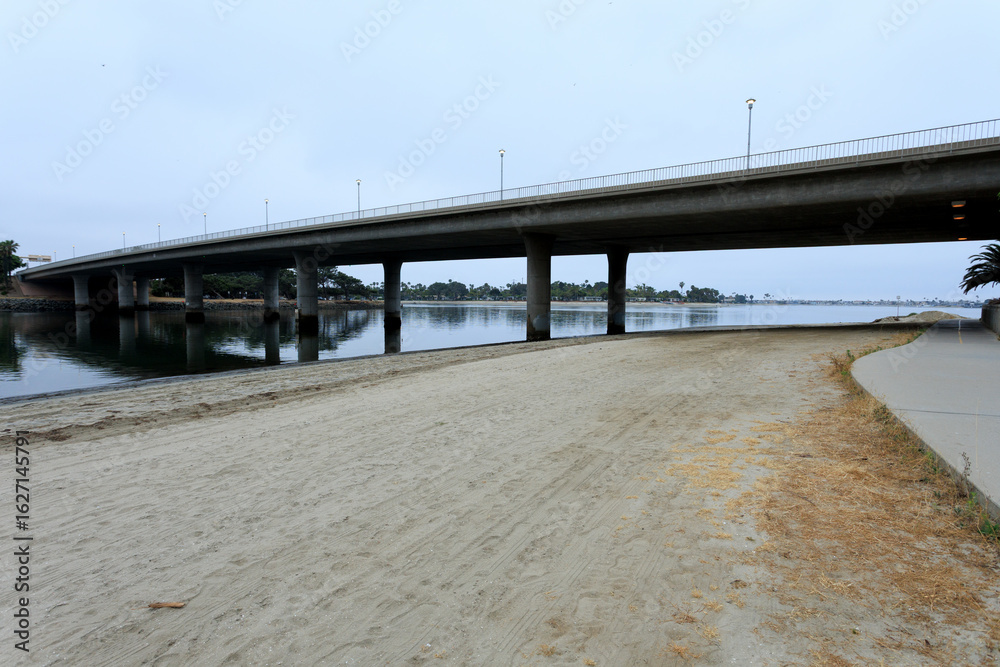 Obraz premium Ingraham street bridge stretching above Fishermans channel and bay sidewalk to Vacation Isle, San Diego, California