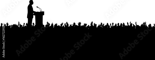 leader speaking to crowd from podium silhouette
