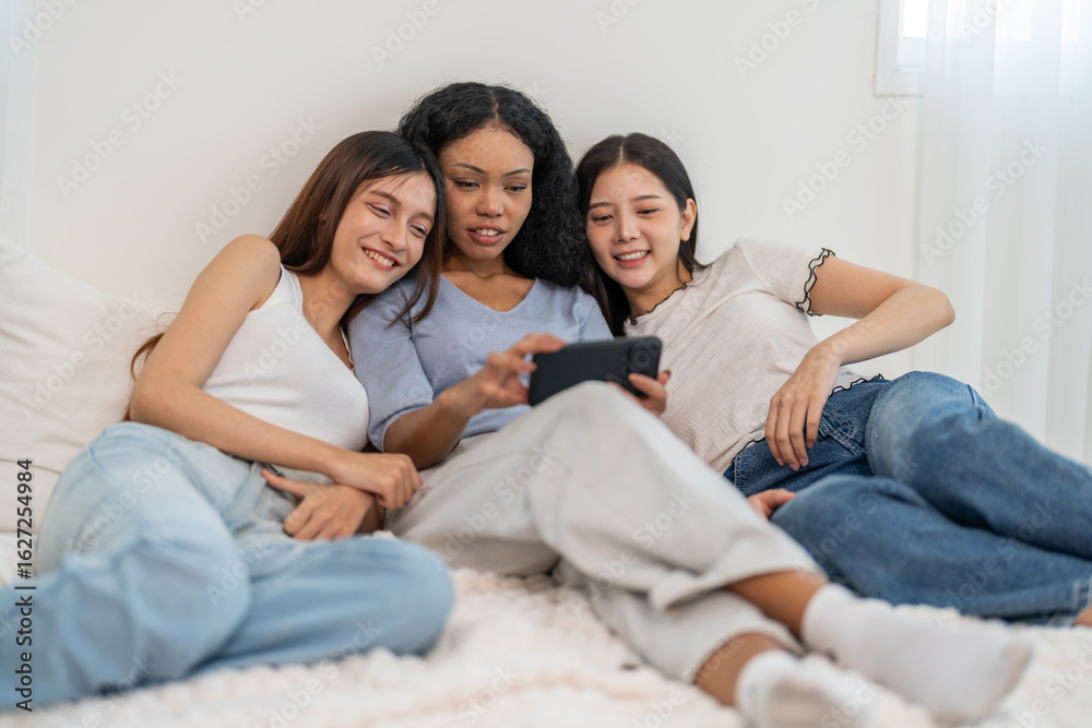 Obraz premium Friends using food delivery app browsing on smartphone at home, young diverse women ordering meals online, enjoying convenience digital lifestyle, social modern technology and online shopping for food