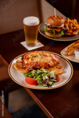 Bild auf Leinwand Chicken Parmigiana With Sides And Beer