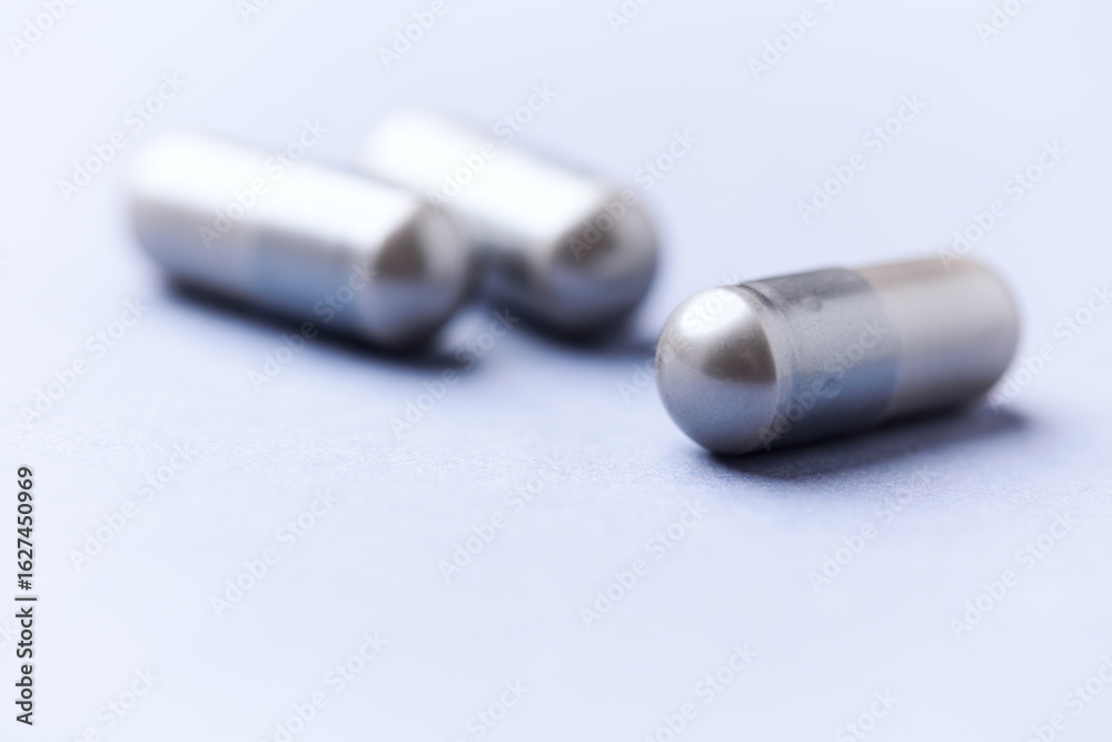 Naklejka premium Amino acids capsules on bright background. Soft focus. Close up. Copy space.