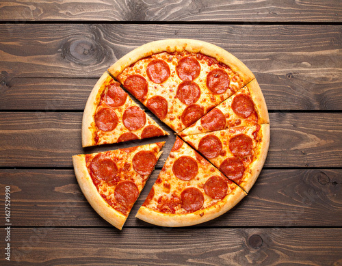 Deliciously Sliced Pepperoni Pizza Ready to Eat on a Rustic Wooden Table