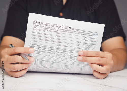 Close-up of hands reviewing federal tax document 1040 form during annual filing season.