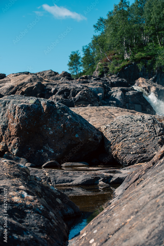 Obraz premium streams of clear waterfall water and stone banks of a mountain river