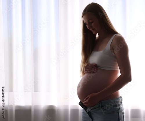 Beautiful pregnant woman near window at home. Space for text Free Download Beautiful pregnant woman near window at home. Space for text - GFXLoad