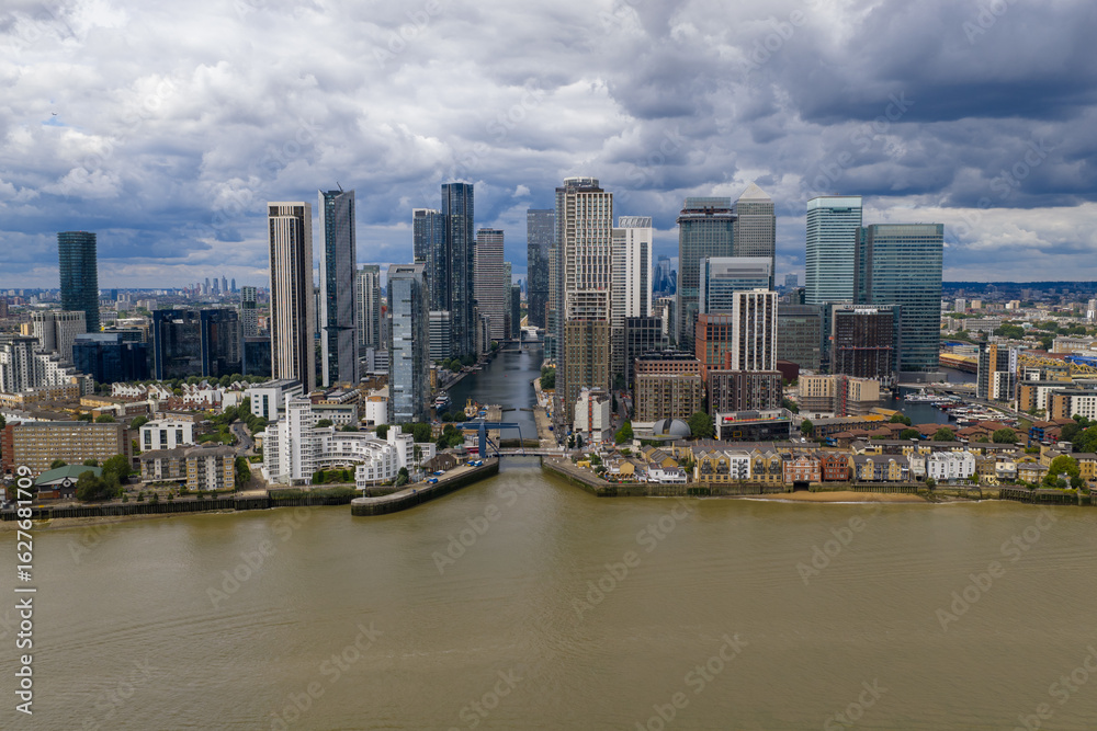 Obraz premium Wide drone view showing the skyline of Canary Wharf aligned with the dock entrance.