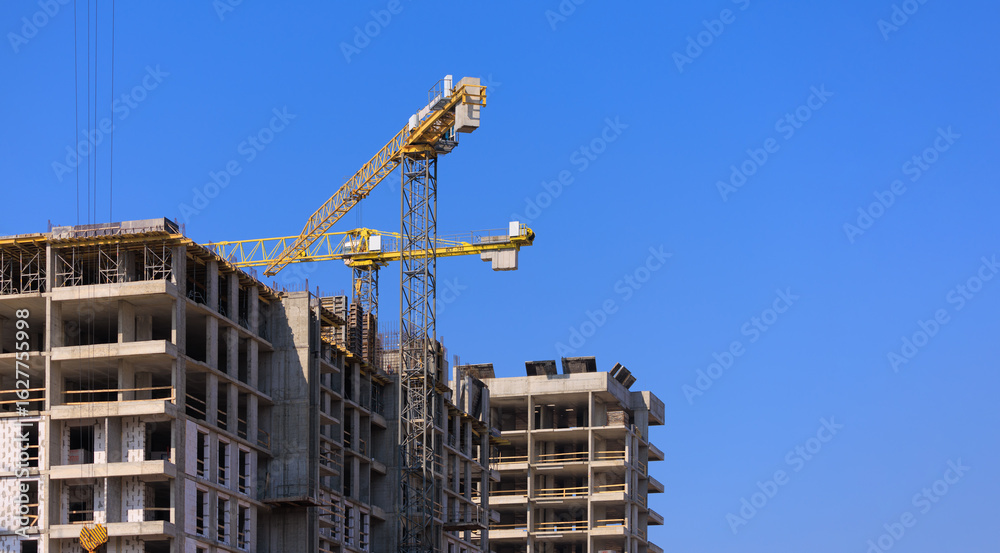 Construction of buildings and high-rise cranes against the blue sky Construction of buildings and high-rise cranes against the blue sky