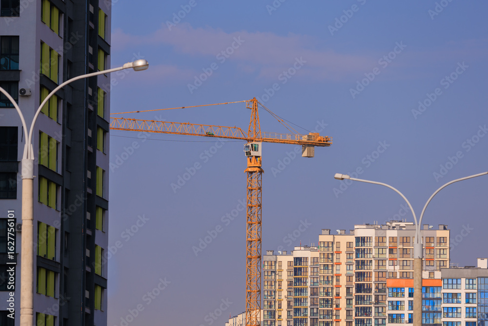 Fototapeta premium Construction of buildings and high-rise cranes against the blue sky