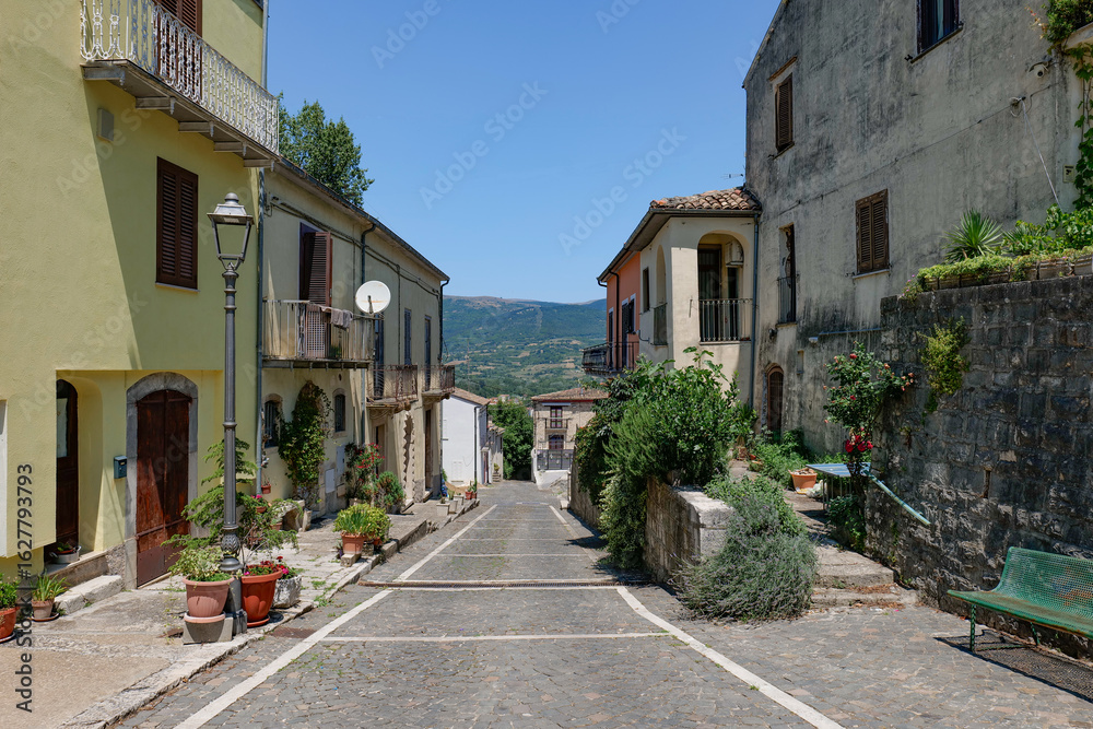 Fototapeta premium A narrow street among the old houses of Cantalupo del Sannio, a small town in Molise, Italy.