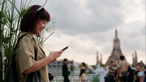 Happy young asian woman experiencing cultural world travel journey in Bangkok, Thailand. solo female tourist explores famous temple landmark with joyful smile