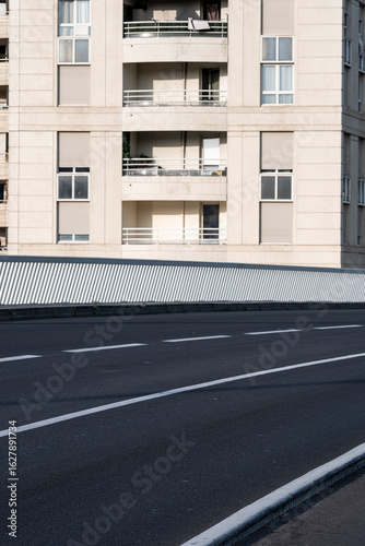 Wallpaper Mural Fresh asphalt road bordered by clean white lines and urban apartments, suitable for mobility innovation, infrastructure development, and modern urban planning commercial representations. Torontodigital.ca