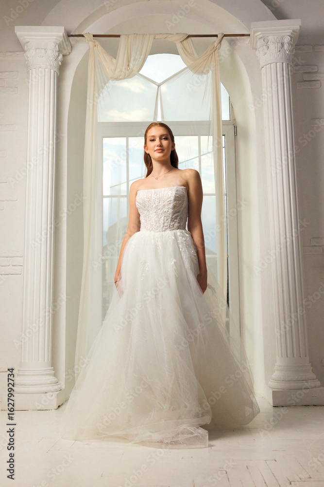 Fototapeta premium Elegant bridal portrait in a bright, airy venue during daylight hours showcasing a stunning white gown