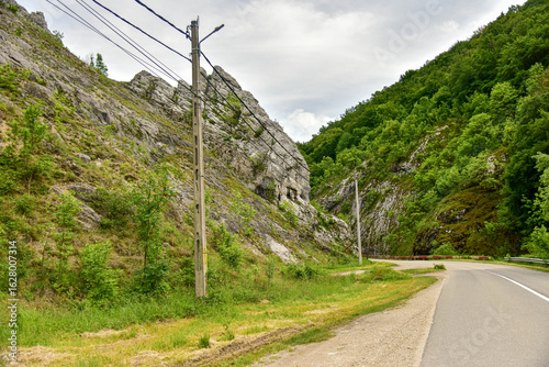 Paredes verticales de piedra rodean una carretera, creando un paso angosto entre la naturaleza salvaje de Rumanía.