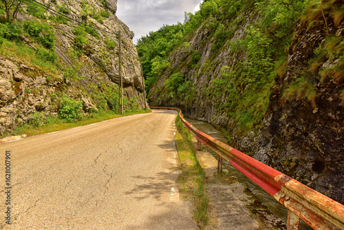 Desfiladero rocoso con carretera estrecha en Intregalde
 Paredes verticales de piedra rodean una carretera rural, creando un paso angosto entre la naturaleza salvaje de Rumanía.

