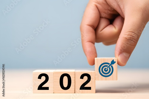 Wallpaper Mural 2024 Target Goals: The image showcases a wooden cube game spelling out 2024, with a hand placing a cube with a target icon. This represents goals and objectives for the new year. Torontodigital.ca