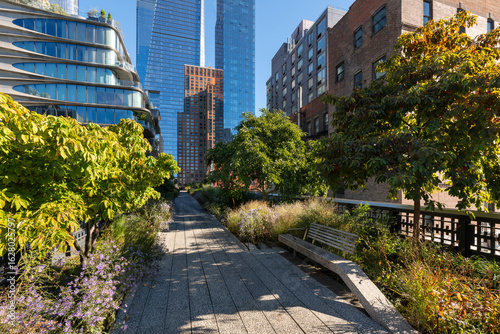 Fototapeta Naklejka Na Ścianę i Meble -  High Line park in Chelsea, New York City with Hudson Yards skyscrapers. Elevated urban greenway with summer foliage and modern architecture