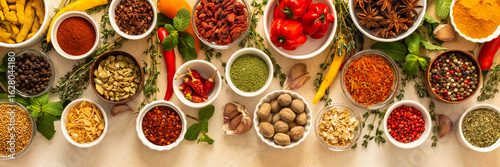 Variety of vibrant spices and dried herbs arranged on a beige backdrop, essential for culinary seasoning and enriching dishes with aromatic, natural flavors, banner