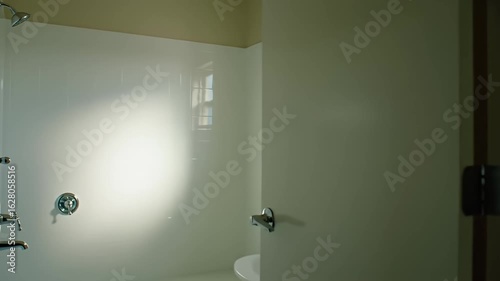 Bright, clean bathroom with white tiling, chrome fixtures, and natural light