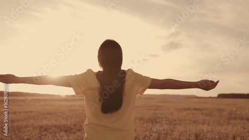 girl with hands raised dreamily meditates sunset. girl's hands rays sun glare. female dream concept. religious prayer background heavenly light park. young girl believes god. contemplate believing