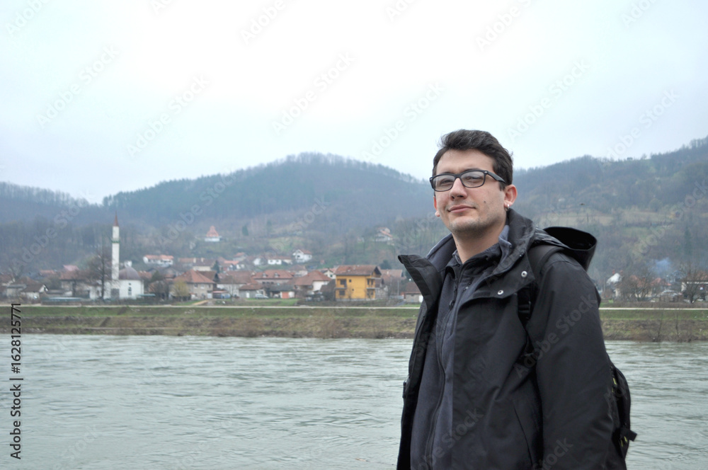 Man on the Drina River in Bosnia and Herzegovina. Turkish man with glasses and earrings is on a Balkan travel. People, model, person. Man on the Drina River in Bosnia and Herzegovina. Turkish man with glasses and earrings is on a Balkan travel. People, model, person.