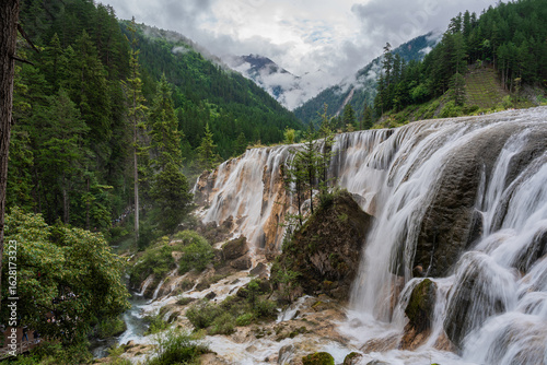 Nuorilang Waterfall or Pearl Shoal Waterfall in Jiuzhaigou national park, China. Summer in Sichuan.