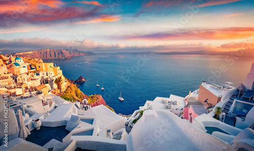 Incredible summer sunrise on Santorini island. Stunning morning cityscape of famous Greek resort Fira, Greece, Europe. Aerial Mediterranean seascape. Traveling concept background.