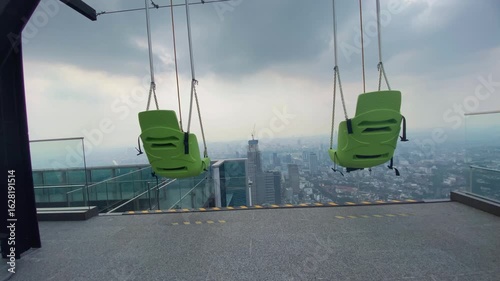 swing set on top of Indonesia's tallest observatory deck with a view of the city skyline