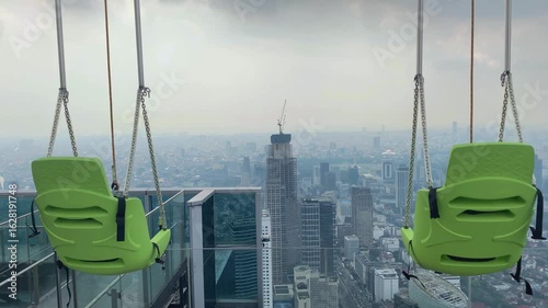 swing set on top of Indonesia's tallest observatory deck with a view of the city skyline