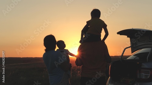 Konstfotografi happy family at sunset travel by car, mom dad and child on tourist trip by transport, family car of young couple, childhood dream, little child on dad shoulders fantasizes about flying, kid picnic