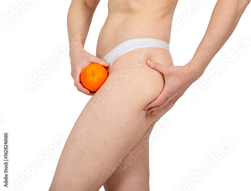 A woman pinches her thigh to show off the skin of her thigh. Concept for fighting cellulite, reducing fat deposits, improving microcirculation and lymphatic drainage, and firming the skin.