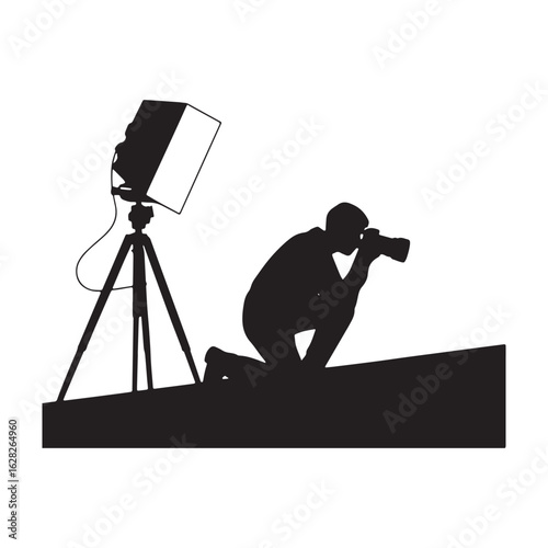 Silhouette of a Photographer Kneeling with Camera and Lighting Equipment on Transparent Backdrop