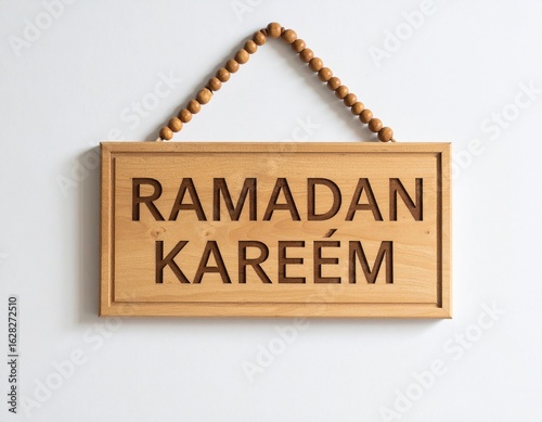 Wallpaper Mural A light brown wooden sign, hanging with beads, displaying the Arabic phrase "Ramadan Kareem". Torontodigital.ca