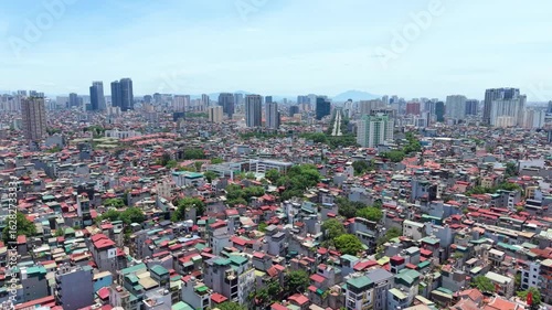 Vietnam, Hanoi: Aerial view of capital city of Vietnam, blend of modern skyscrapers, historic buildings, and lush greenery under blue sky - landscape panorama of Southeast Asia from above
