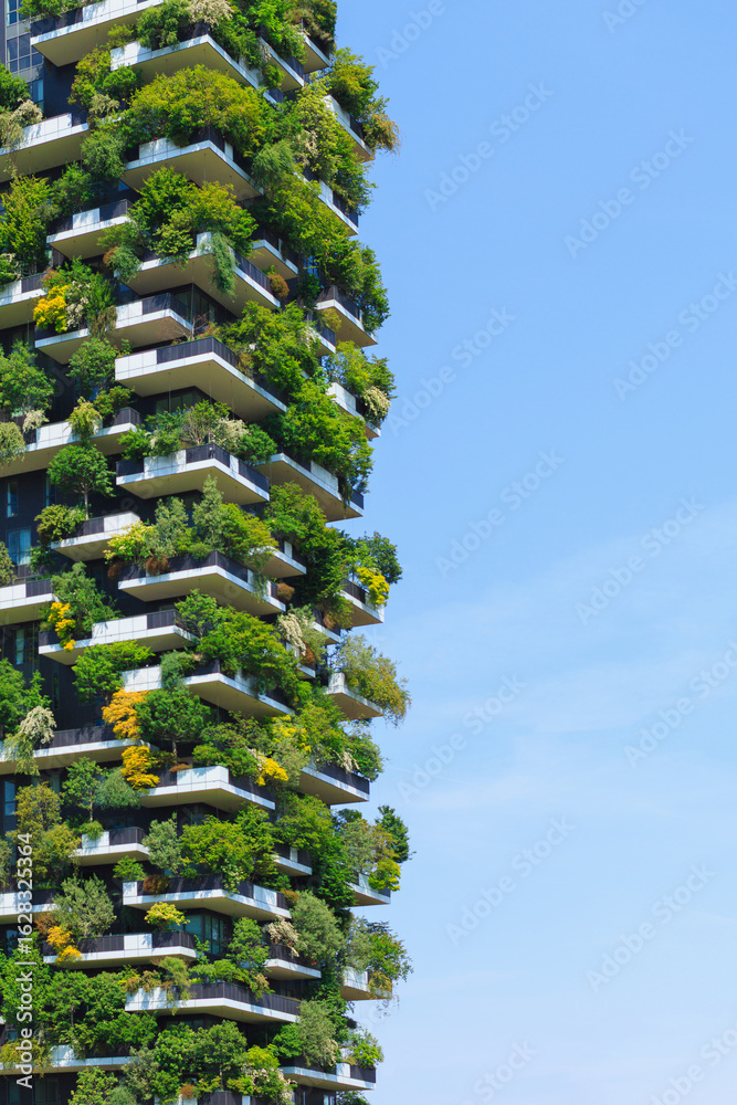 Fototapeta premium A stunning view of a green covered sustaineble building showcases innovative architecture blending nature and urban living under clear sky.
