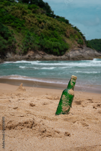 Green Bottle Glass Of Water On The Beach