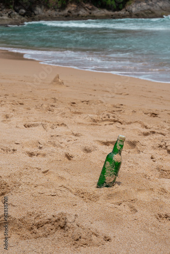 Green Bottle Glass Of Water On The Beach
