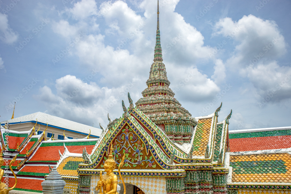 Fototapeta premium Beautiful entrance gate with golden guardian warriors of one of the temples of the Grand Palace in Bangkok, Thailand