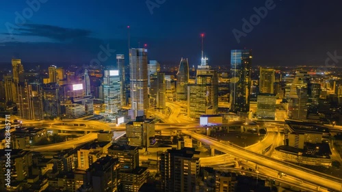 Izmir's modern cityscape lights up the night sky, showcasing a complex highway interchange with flowing traffic and prominent skyscrapers, creating a dynamic urban scene in turkey