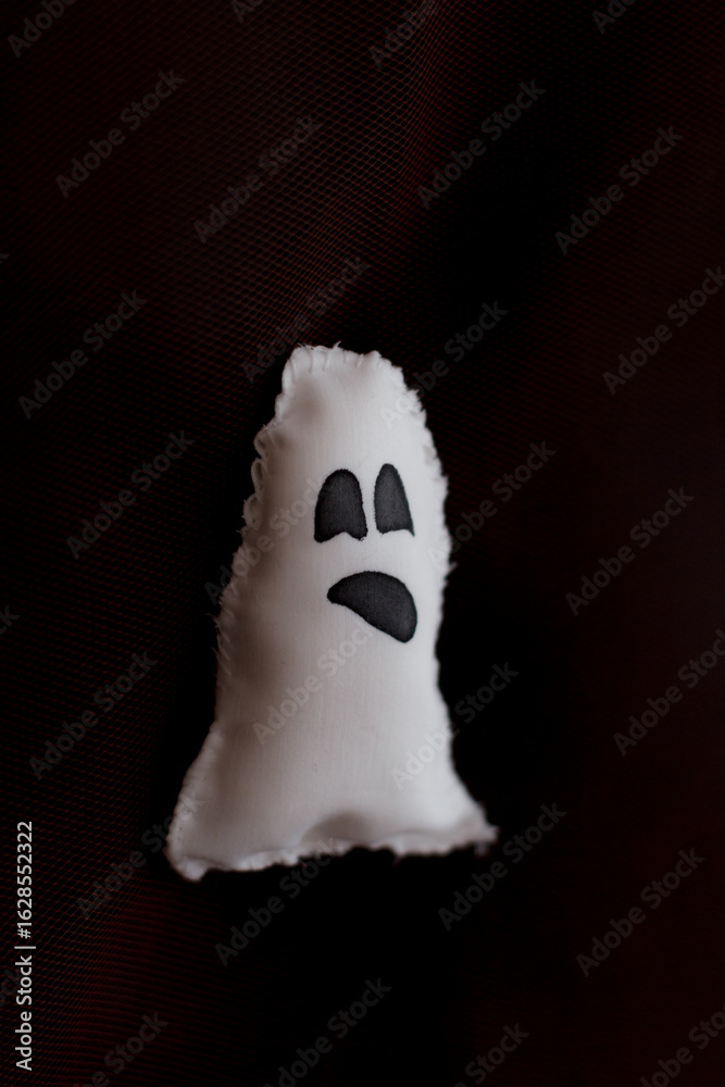 Naklejka premium White ghost plushie hanging on dark background for halloween party decoration