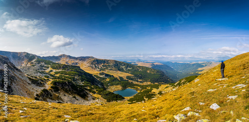 Experience a breathtaking autumn day in the wild Carpathian Mountains, near Lake Galcescu, in the Parang Mountains of Romania, where vibrant fall colors meet rugged peaks