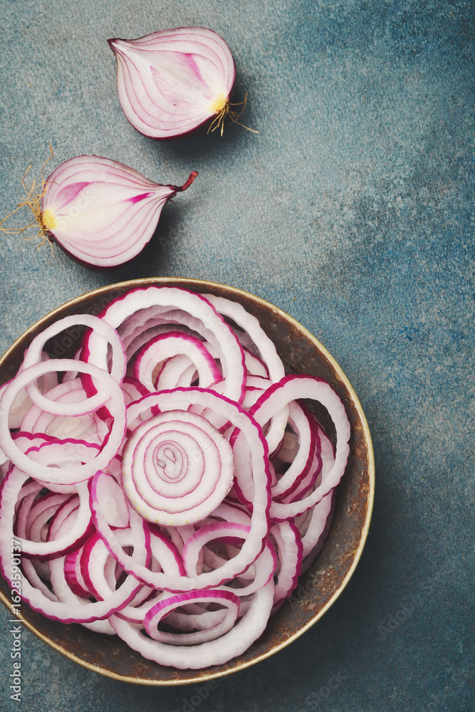 Fototapeta premium Sliced red onion rings in a bowl. Top view. Close-up.