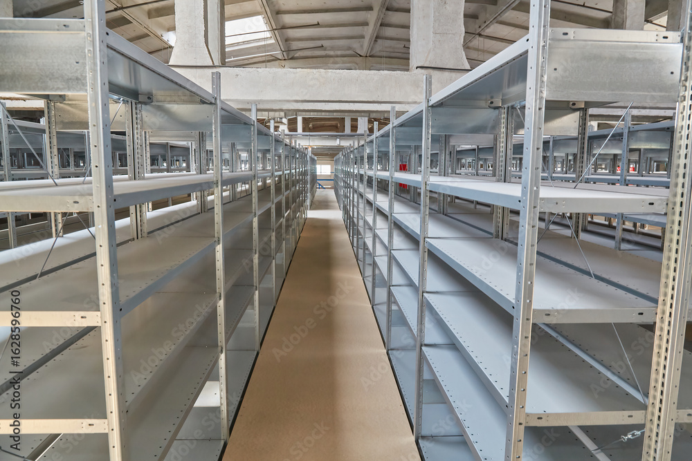Fototapeta premium Empty Metal Shelving Units in Warehouse Aisle