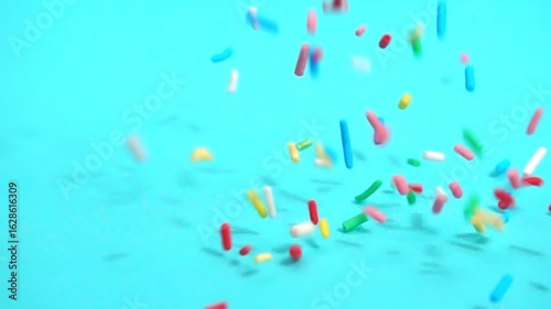 beautiful slow fall of bright sprinkles against tranquil blue backdrop, creating playful and charming scene for any project
