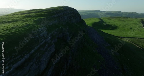 Rocky ridge and green pastures in Yorkshire Dales, England