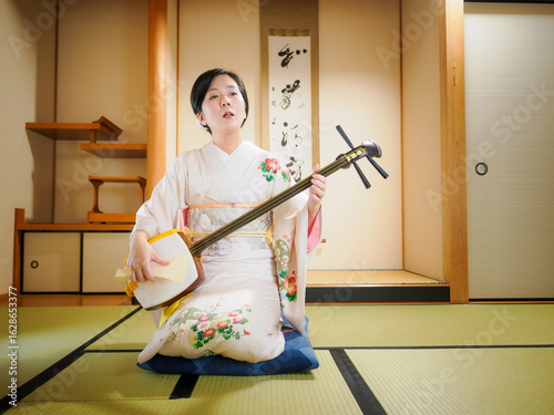 着物で三味線を演奏する女性