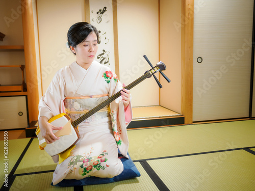 着物で三味線を演奏する女性