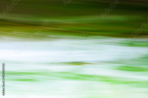 Bilde på lerret Abstract photo of a blurry river with green and white motion lines for a background