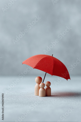 Wallpaper Mural Symbolic shot of a wooden family of three shielded by a vibrant red umbrella. Represents security, protection, and family wellbeing. Use for insurance, care, and safety concepts. Torontodigital.ca