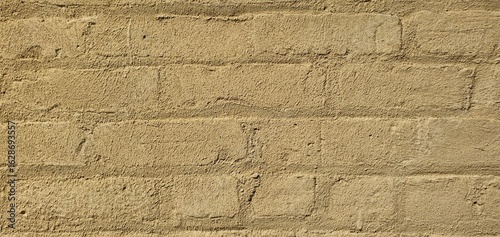 Beige painted brick wall with rough textured surface. Minimalist background for design, construction, and architectural details
