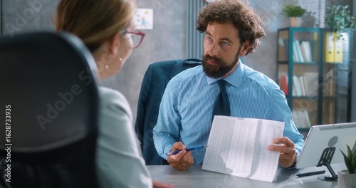 Bank employee manager explains loan options and interest rates to a female client, pointing to documents during a professional financial consultation at the office. Part 21 of the “Dad’s Day” series.